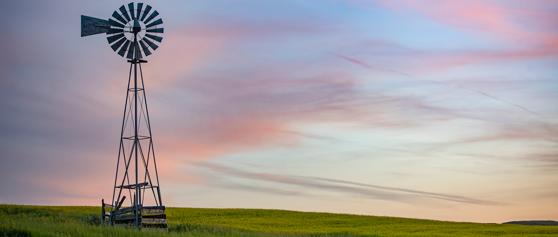 Windmill in a field during sunset